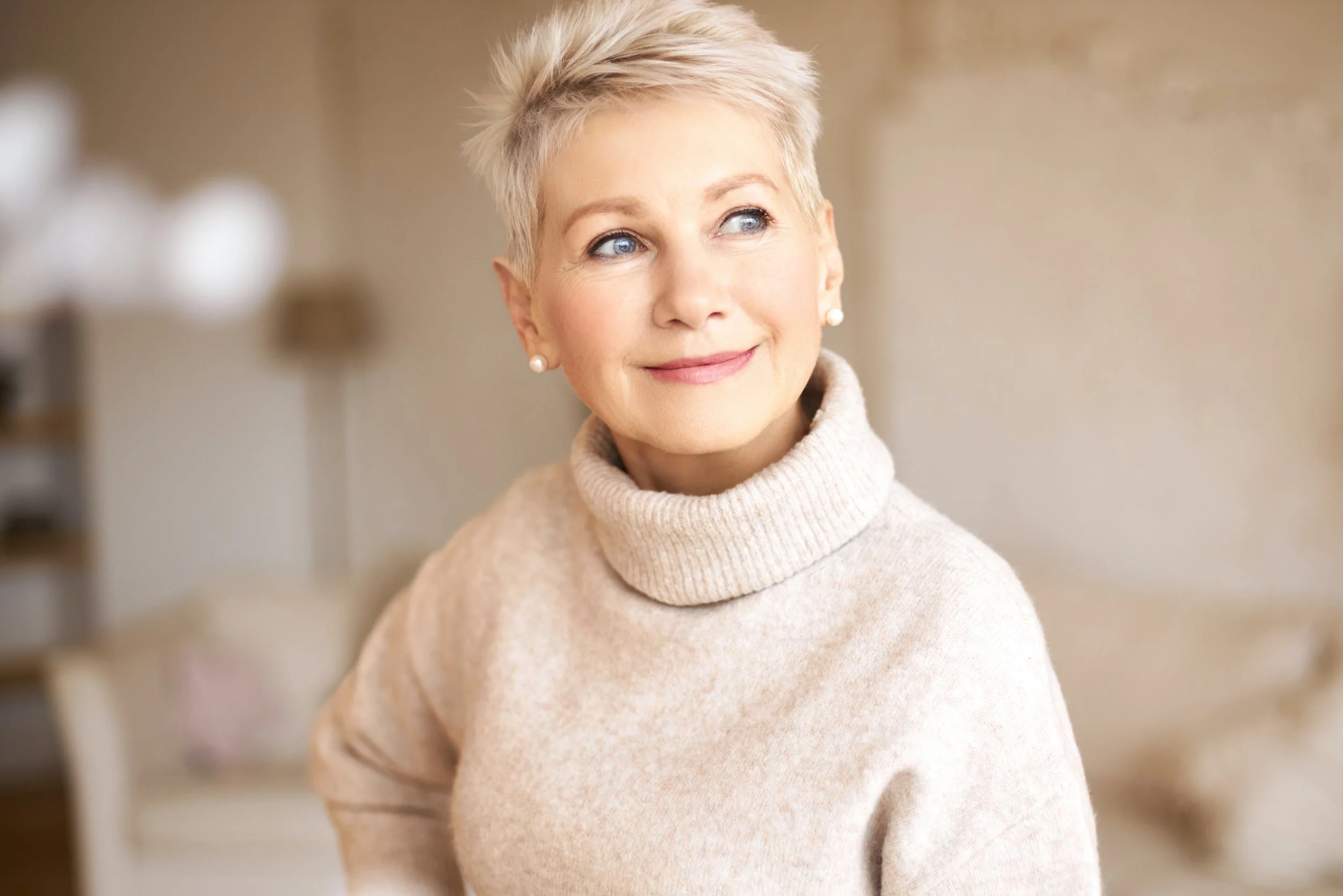 Beautiful happy retired woman wearing cozy sweater